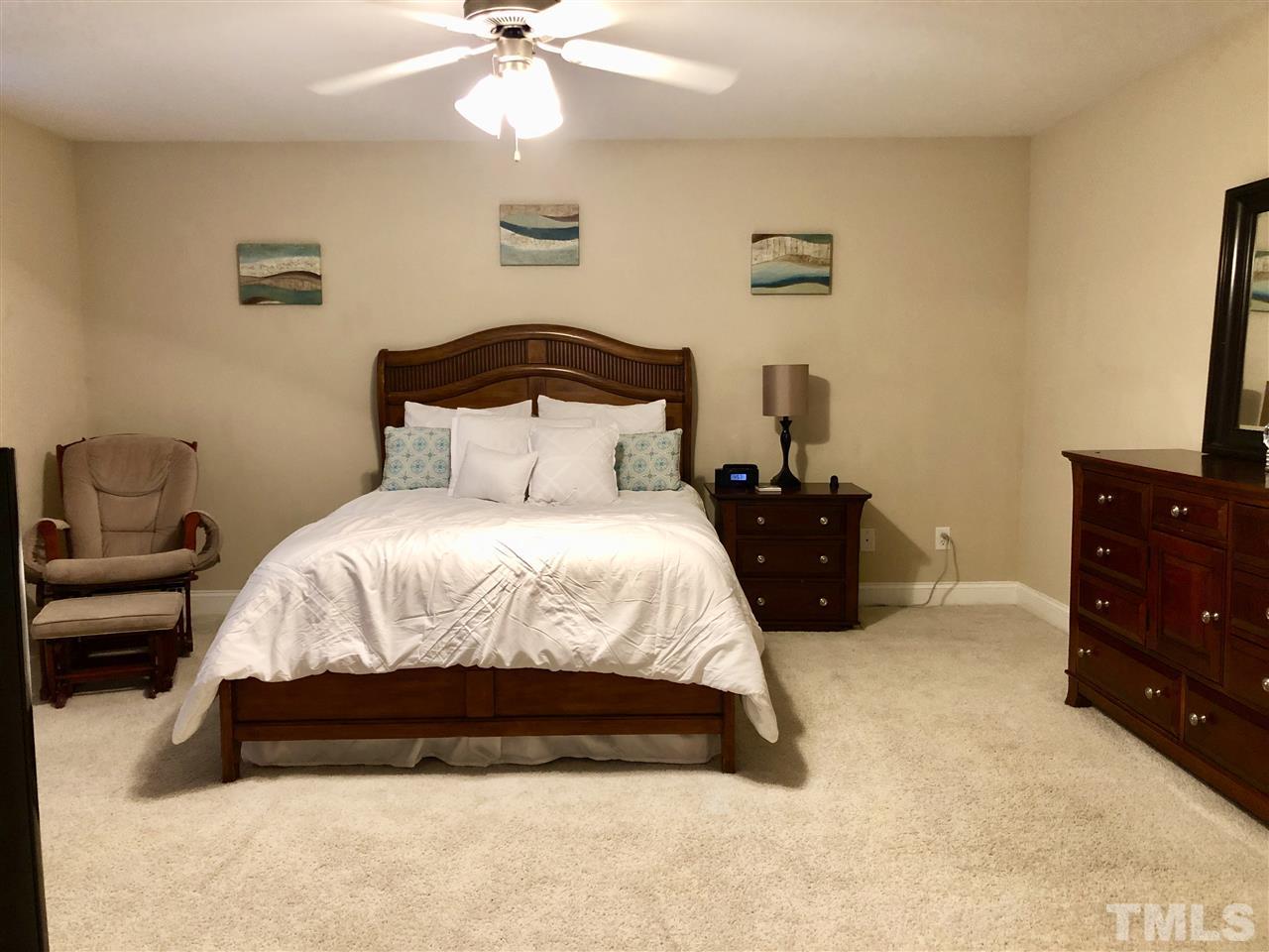 3914 Magnolia Pond Road Raleigh, NC 27610 - Photo 9 of 15 a bedroom with a bed and a chandelier