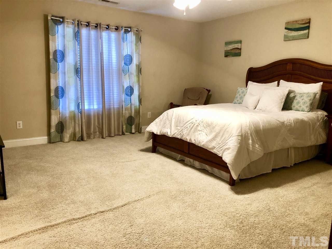 3914 Magnolia Pond Road Raleigh, NC 27610 - Photo 10 of 15 a bedroom with a bed and a wall painting