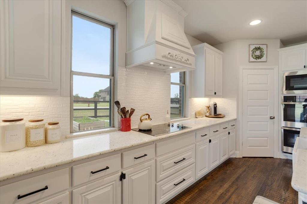 1205 Redbud Street Howe, TX 75459 - Photo 9 of 40 a kitchen with cabinets stainless steel appliances a sink and a window