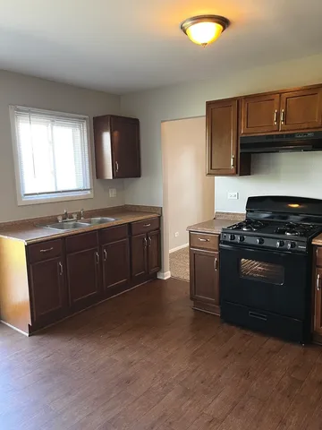 a kitchen with stainless steel appliances granite countertop a stove a sink and a microwave