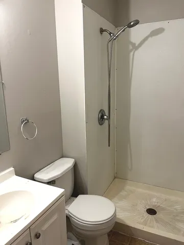 a bathroom with a toilet and a shower
