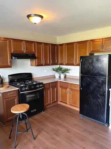 a kitchen with a stove a refrigerator and a sink