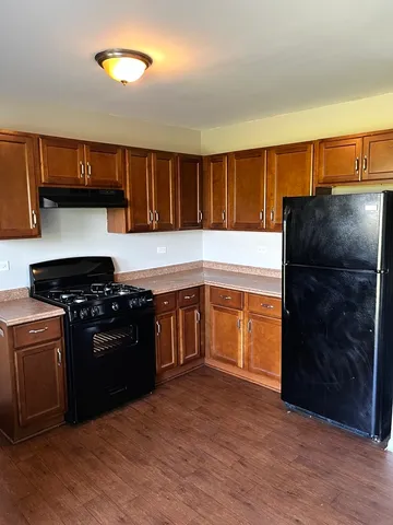 a kitchen with a stove a refrigerator and a sink