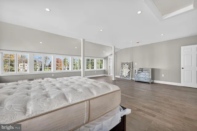 a spacious bedroom with a large bed and a large window