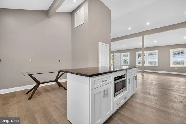 a kitchen with granite countertop a stove and wooden floor