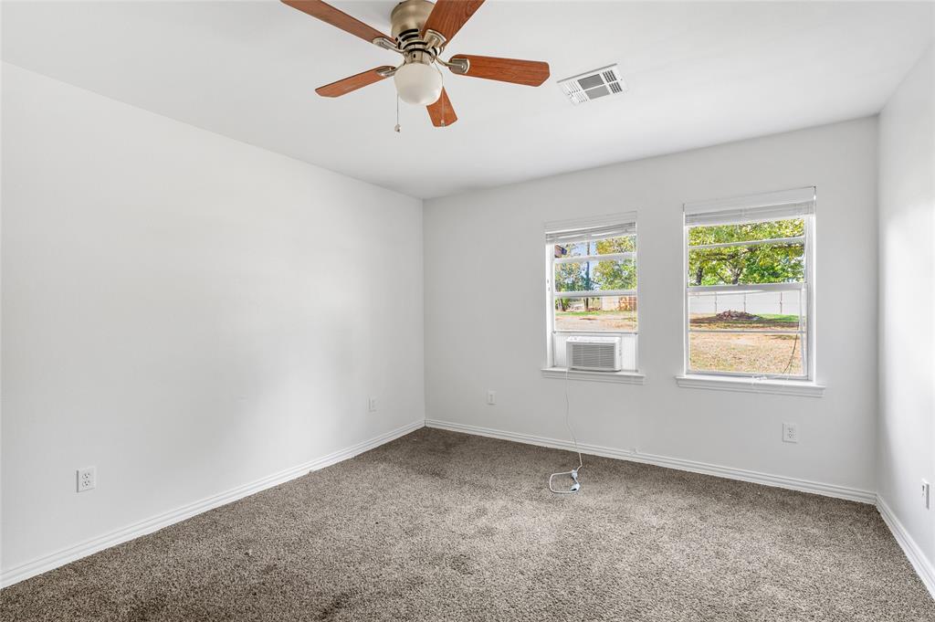 531 Coe Road Denison, TX 75021 - Photo 12 of 22 an empty room with windows and fan