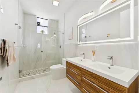 a bathroom with a double vanity sink toilet and shower