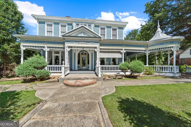 a living room with furniture a fireplace and a chandelier