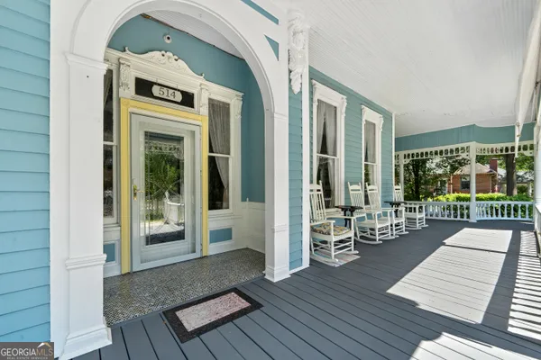 a living room with furniture a chandelier a large window and a chandelier