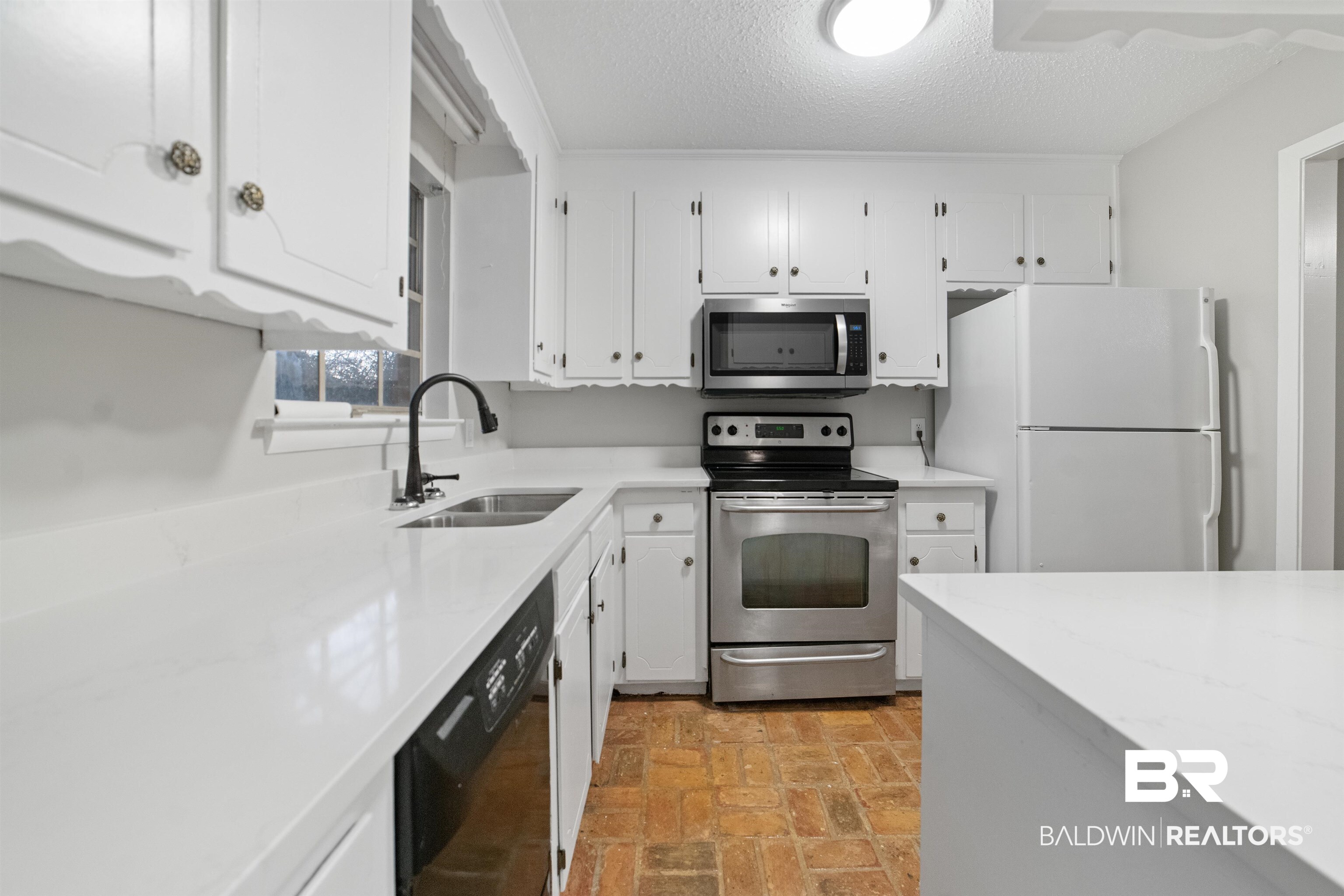 11833 Old Moffat Road Wilmer, AL 36587 - Photo 5 of 23 Kitchen featuring brick floor, light countertops, appliances with stainless steel finishes, white cabinetry, and a sink