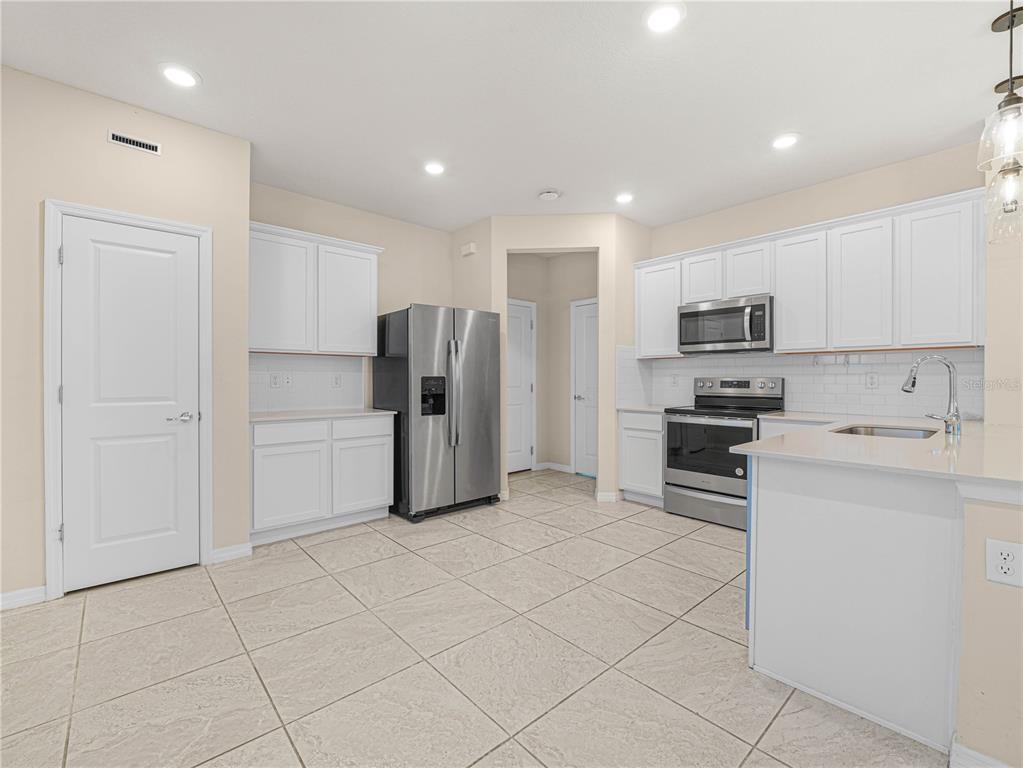 4580 Sparkling Shell Avenue Kissimmee, FL 34746 - Photo 17 of 42 a kitchen with stainless steel appliances a refrigerator sink and microwave