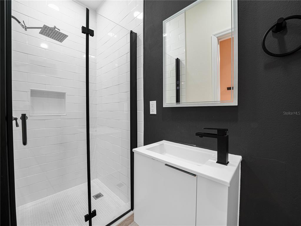 4580 Sparkling Shell Avenue Kissimmee, FL 34746 - Photo 22 of 42 a bathroom with a sink a mirror and a shower