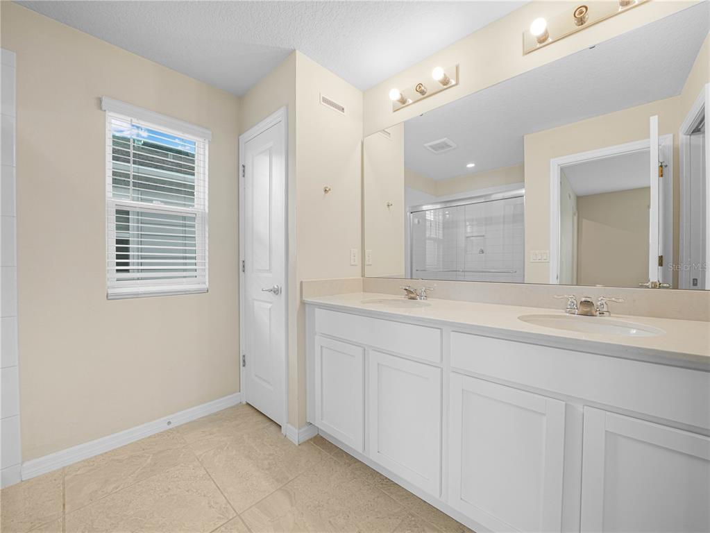 4580 Sparkling Shell Avenue Kissimmee, FL 34746 - Photo 30 of 42 a bathroom with double sink and a mirror