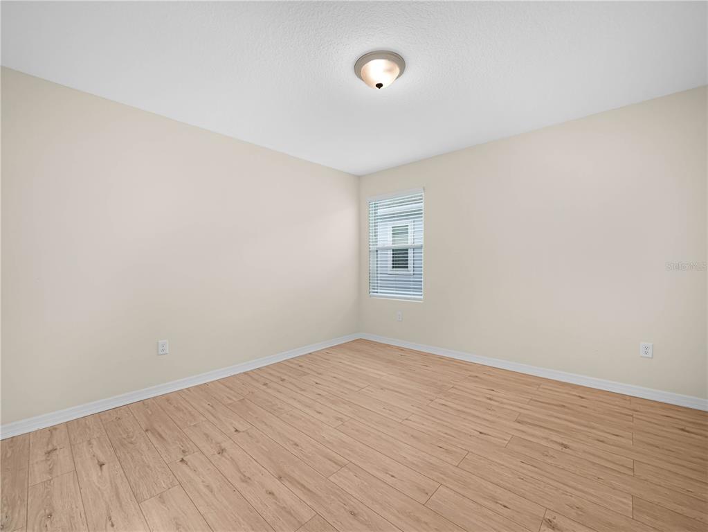 4580 Sparkling Shell Avenue Kissimmee, FL 34746 - Photo 38 of 42 an empty room with wooden floor and windows