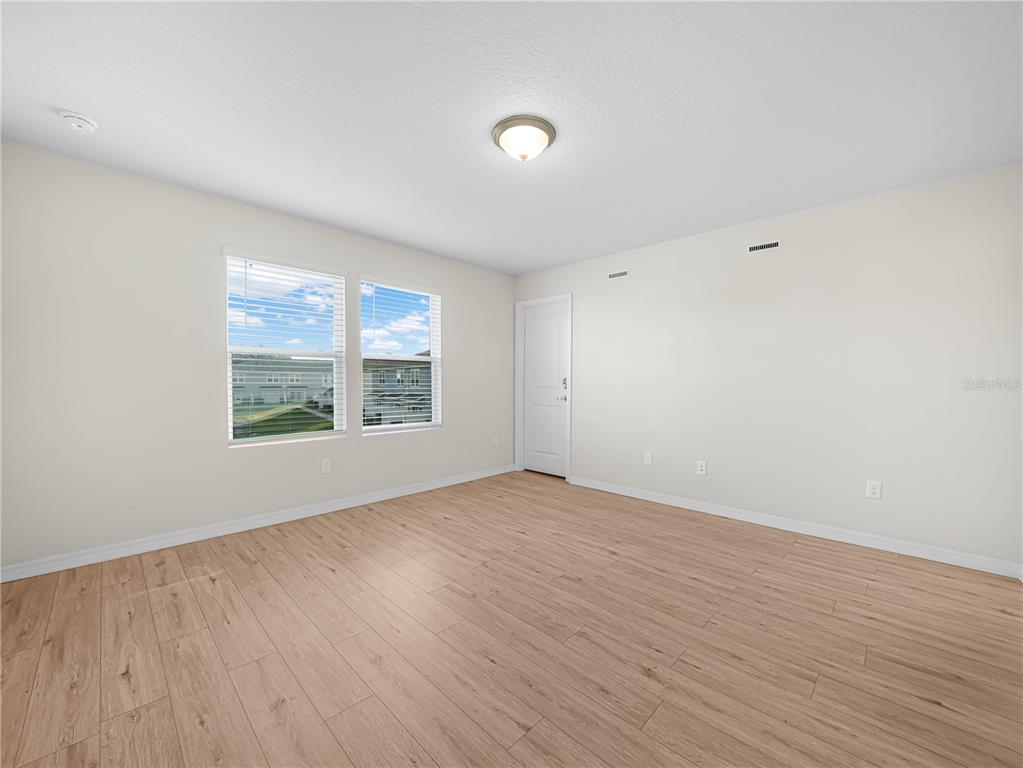 4580 Sparkling Shell Avenue Kissimmee, FL 34746 - Photo 41 of 42 an empty room with wooden floor and windows