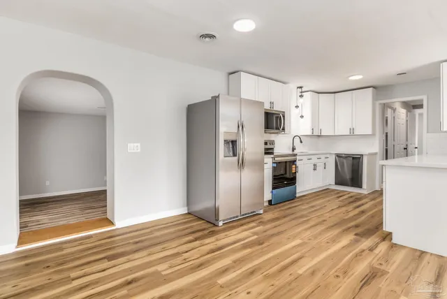a kitchen with stainless steel appliances a refrigerator and a stove top oven