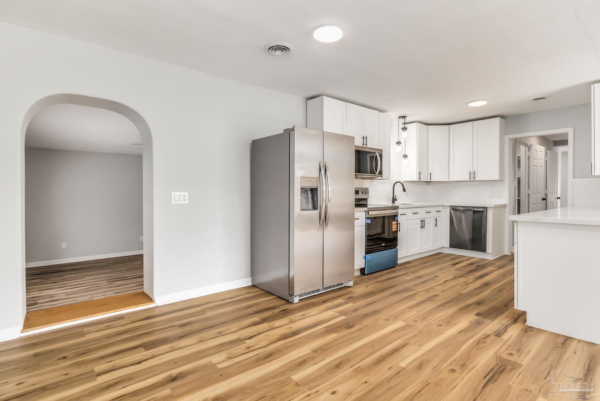 6357 Shady Lane Milton, FL 32570 - Photo 11 of 57 a kitchen with stainless steel appliances a refrigerator and a stove top oven