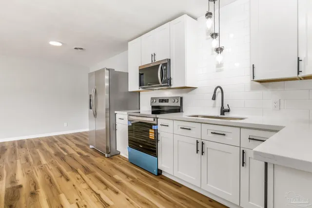 a kitchen with stainless steel appliances a stove microwave and sink