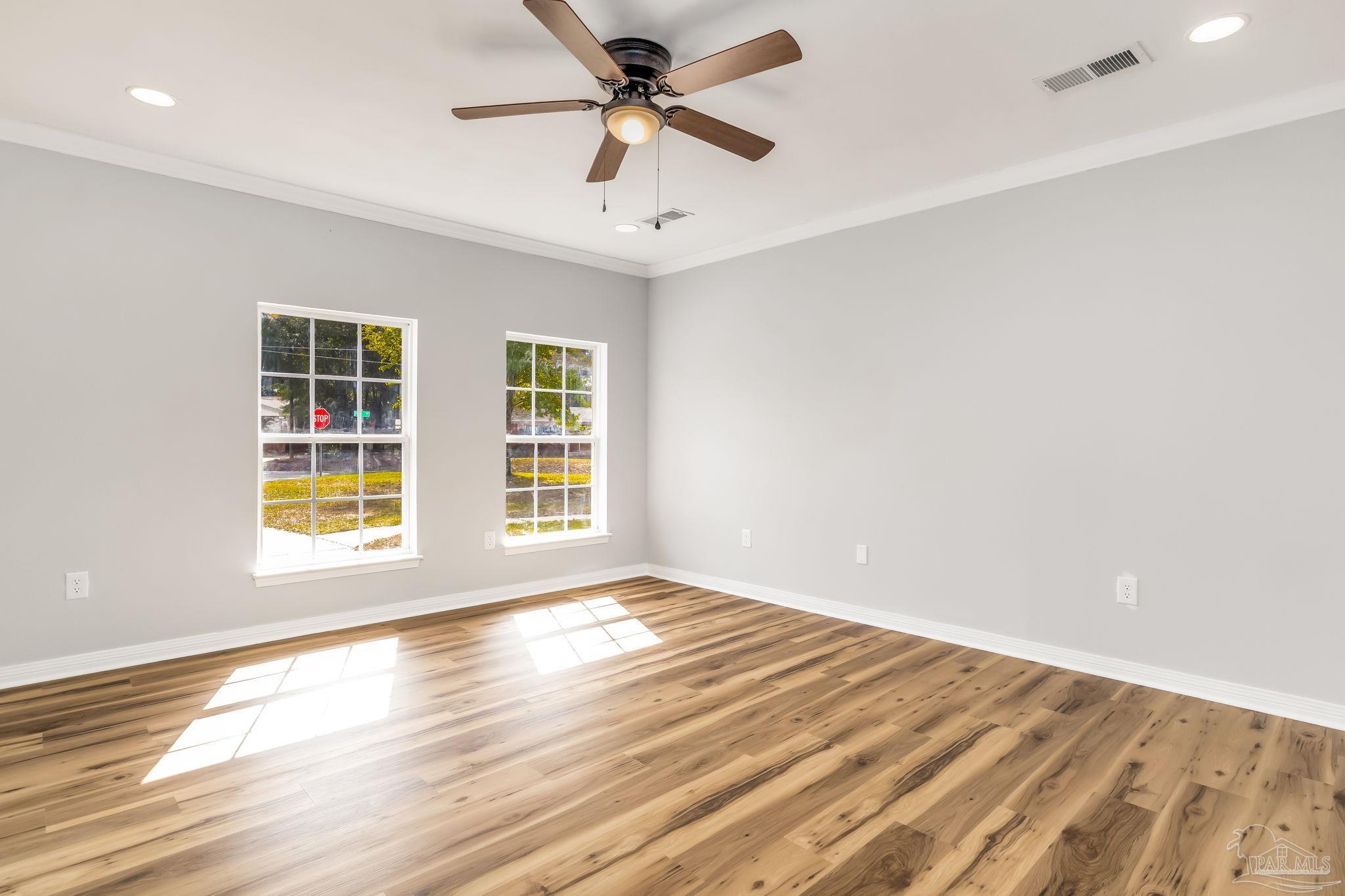 6357 Shady Lane Milton, FL 32570 - Photo 18 of 57 a view of an empty room with wooden floor and a window