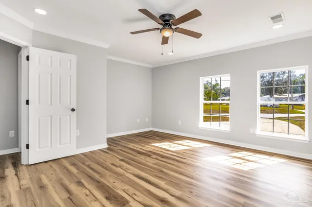 a view of a room with wooden floor and a ceiling fan
