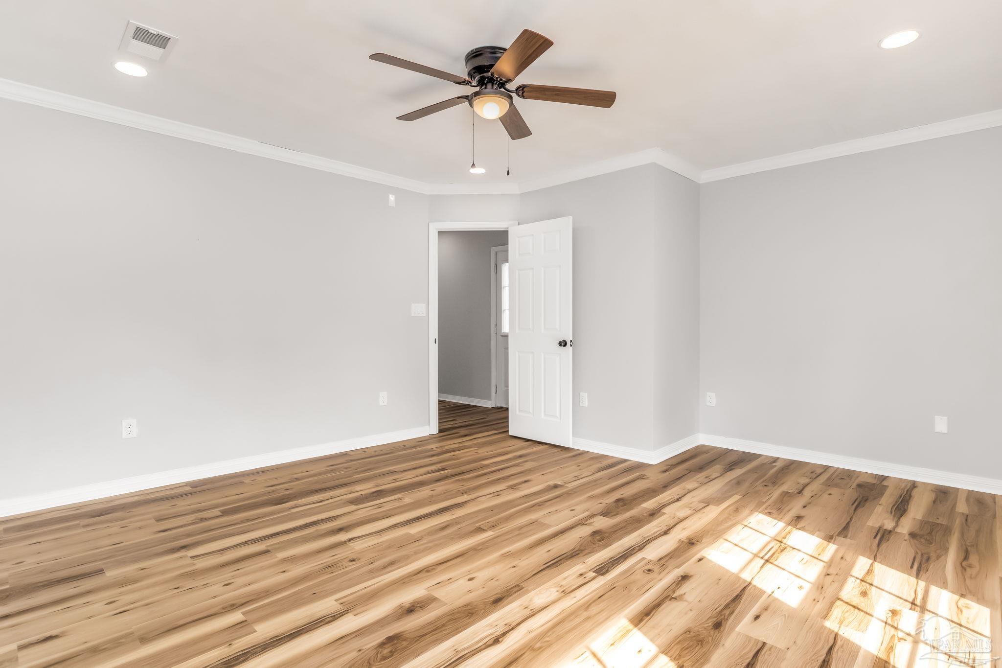 6357 Shady Lane Milton, FL 32570 - Photo 20 of 57 a view of a room with wooden floor and a ceiling fan