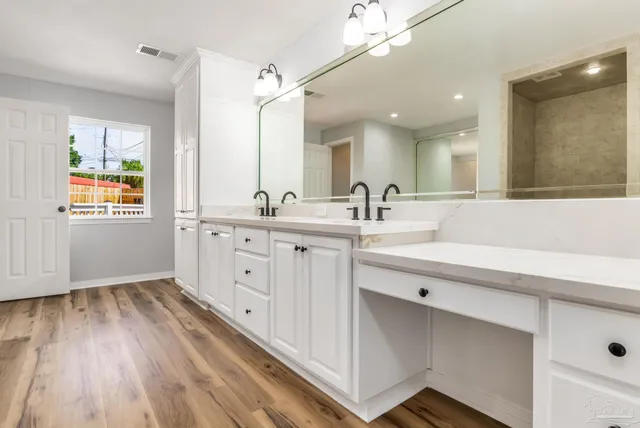 a view of a bathroom with mirror and a sink