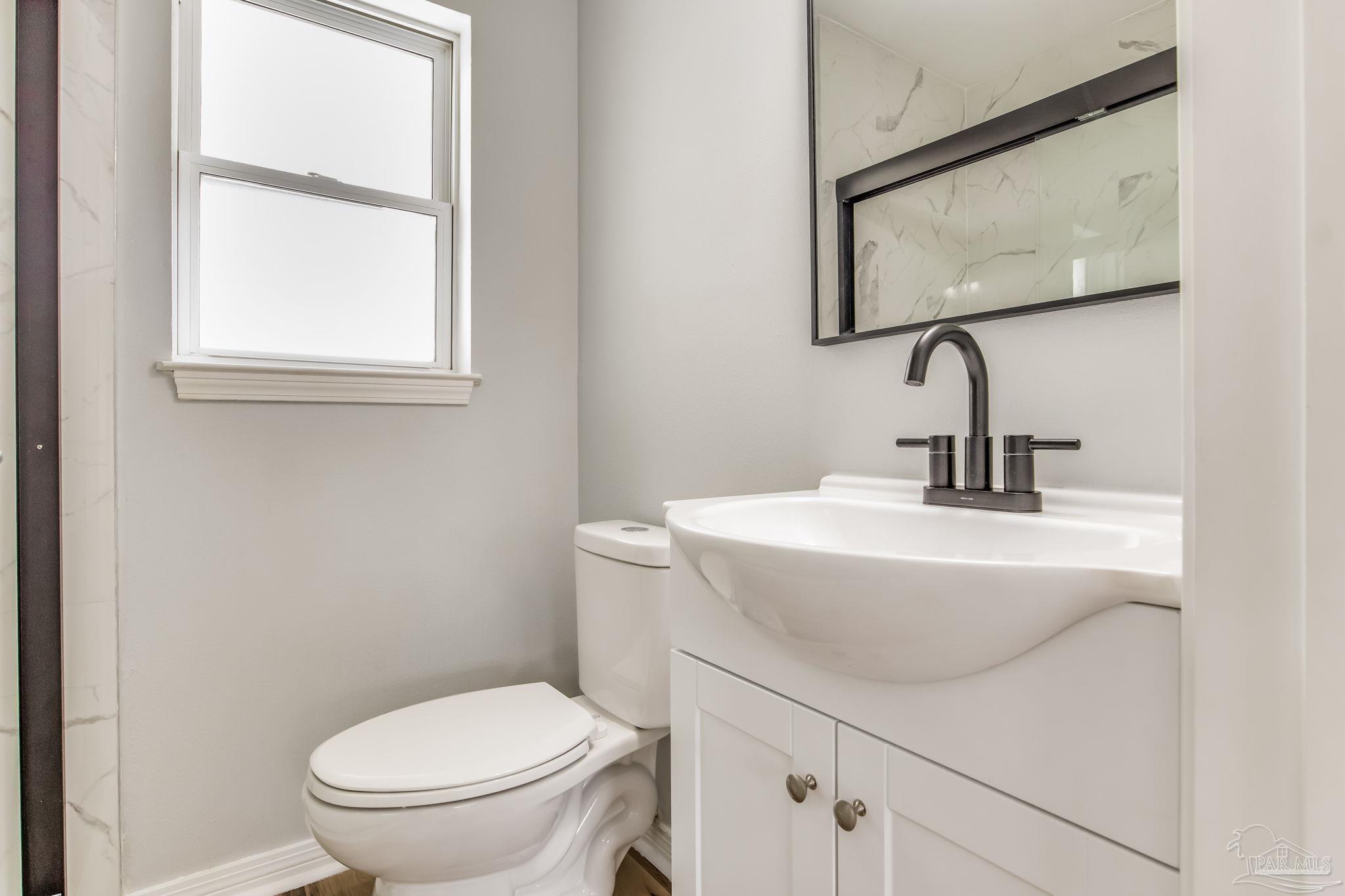 6357 Shady Lane Milton, FL 32570 - Photo 32 of 57 a bathroom with a toilet sink and mirror