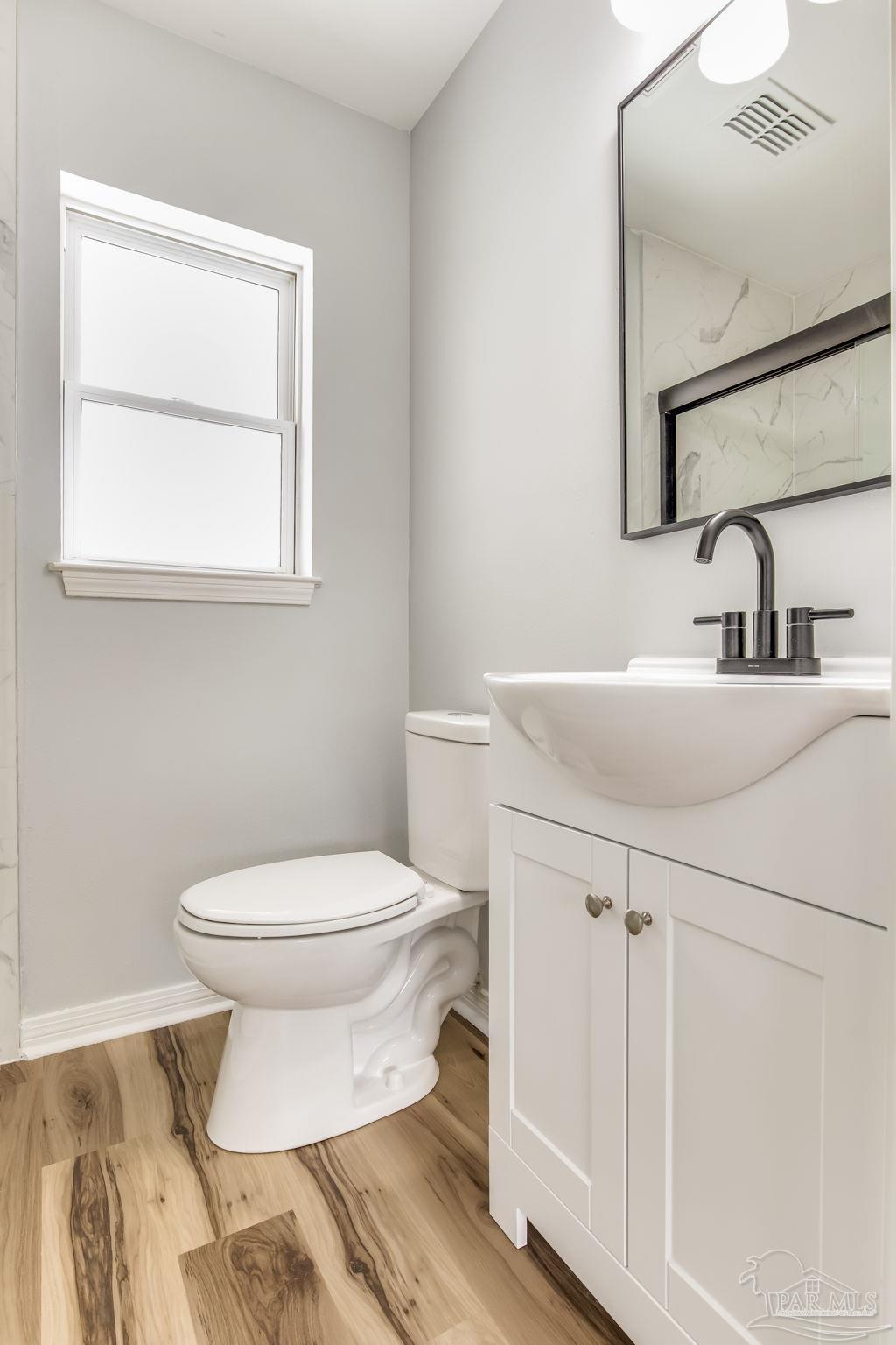 6357 Shady Lane Milton, FL 32570 - Photo 33 of 57 a bathroom with a sink toilet and mirror