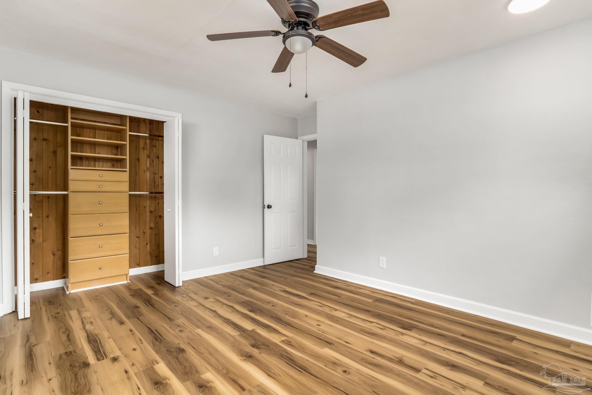 6357 Shady Lane Milton, FL 32570 - Photo 35 of 57 a view of a livingroom with wooden floor and a ceiling fan