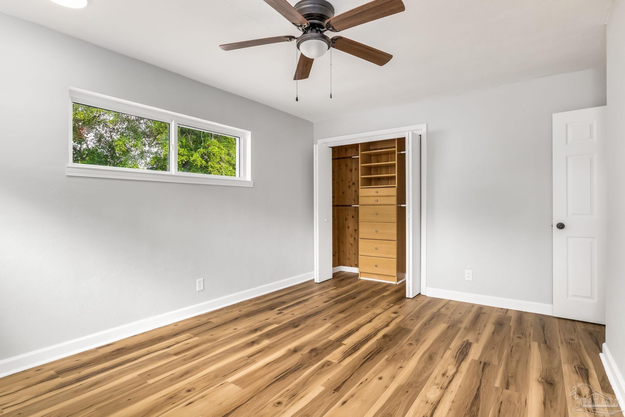 6357 Shady Lane Milton, FL 32570 - Photo 36 of 57 a view of an empty room with a window and wooden floor