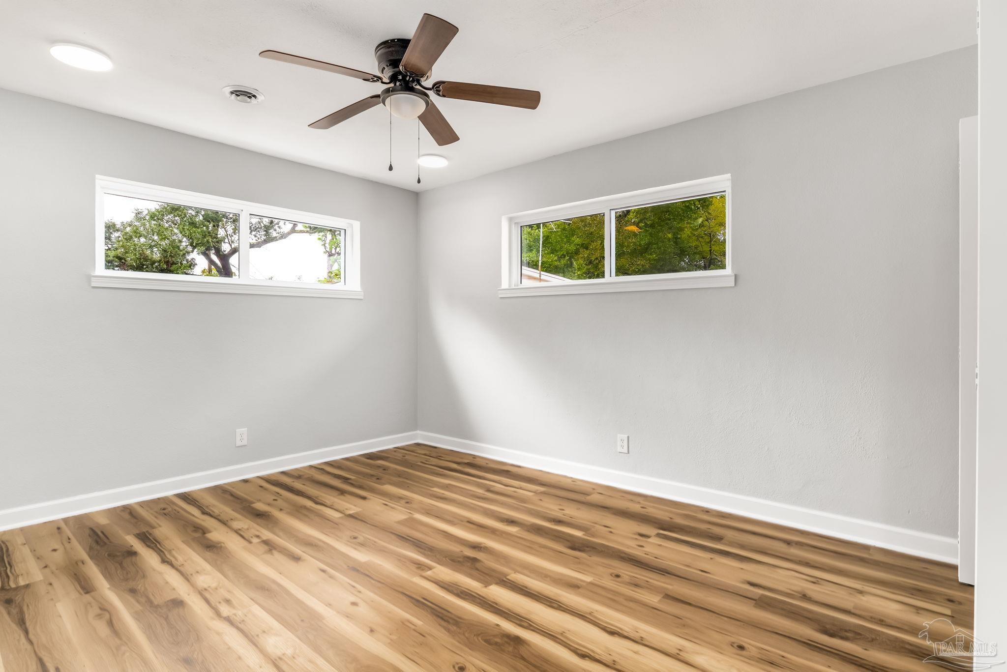 6357 Shady Lane Milton, FL 32570 - Photo 38 of 57 a view of a big room with wooden floor and a ceiling fan