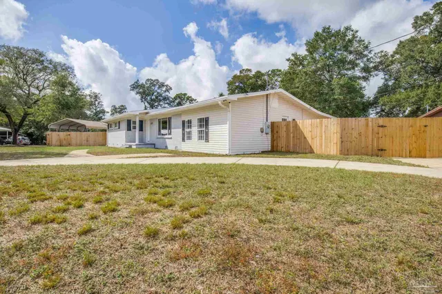 a front view of a house with a yard balcony and lake view
