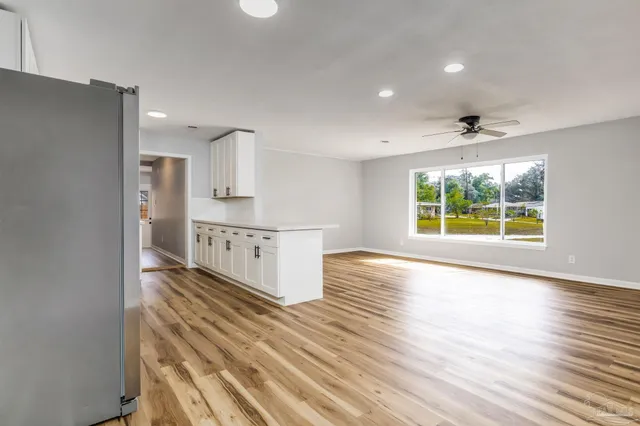 a view of a kitchen with furniture and wooden floor