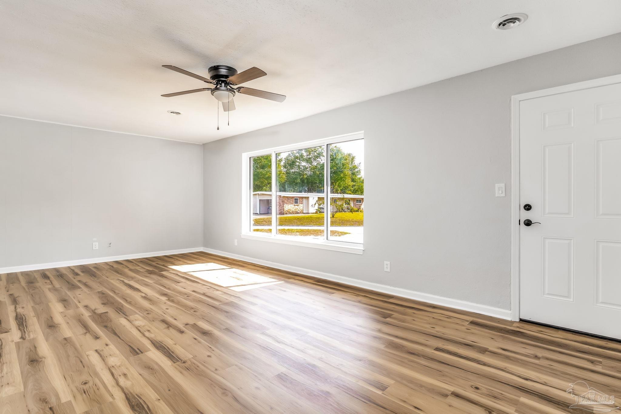 6357 Shady Lane Milton, FL 32570 - Photo 10 of 57 a view of an empty room with wooden floor and a window