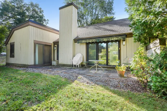 a view of a house with backyard and sitting area