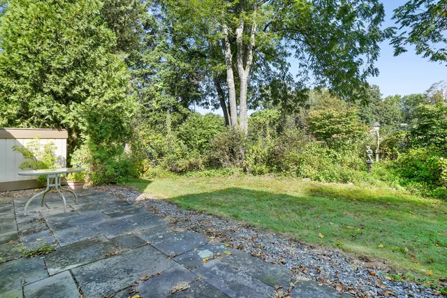 a view of a backyard with table and chairs under an umbrella