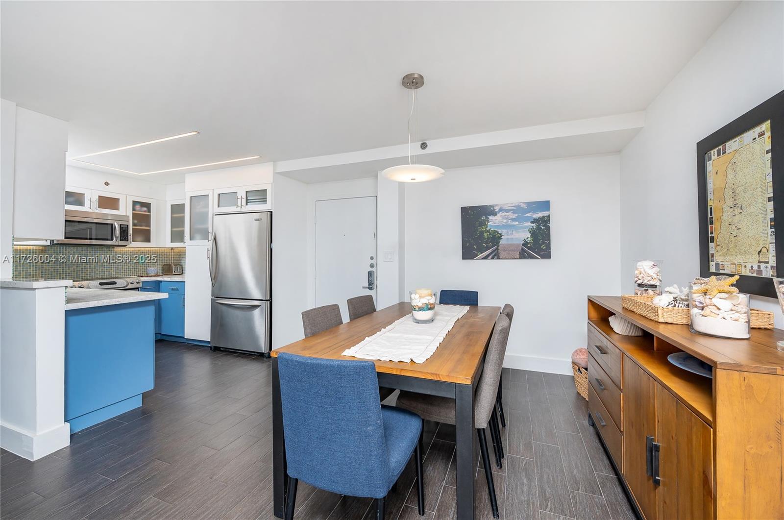 4301 Collins Avenue, Unit 1003 Miami Beach, FL 33140 - Photo 4 of 37 a kitchen with stainless steel appliances wooden floor dining table and chairs
