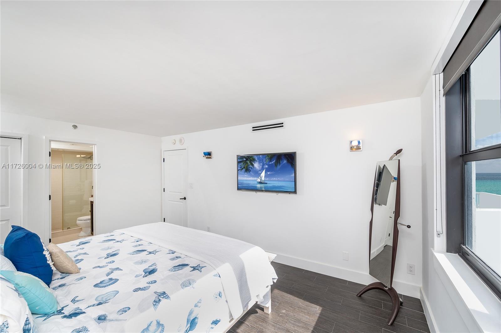 4301 Collins Avenue, Unit 1003 Miami Beach, FL 33140 - Photo 10 of 37 a bedroom with a bed and a flat screen tv