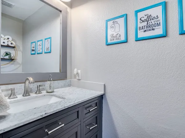 a bathroom with a granite countertop sink and a mirror
