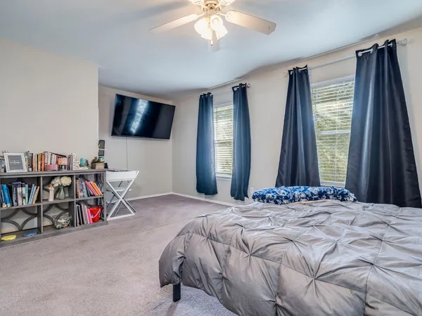 a bedroom with a bed a flat screen tv and a large window