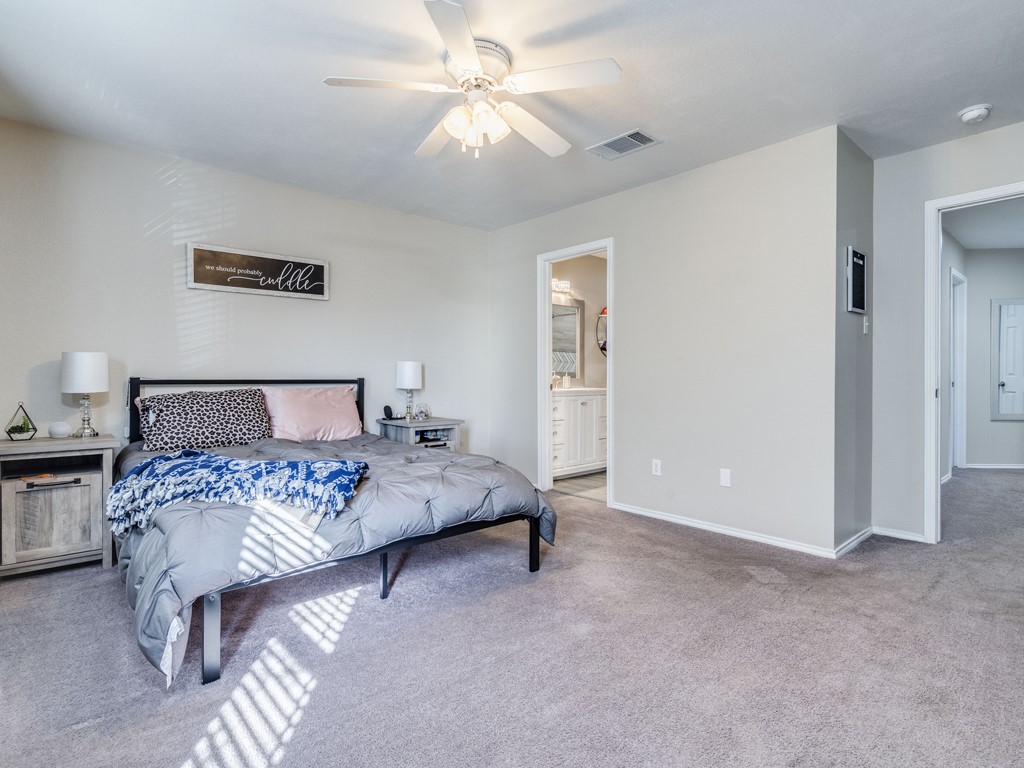13021 Maidenhair Trail Elgin, TX 78621 - Photo 14 of 25 a bed room with a bed and a chandelier