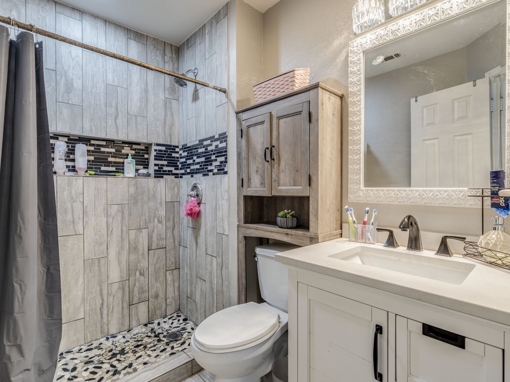 13021 Maidenhair Trail Elgin, TX 78621 - Photo 22 of 25 a bathroom with a sink a toilet and shower