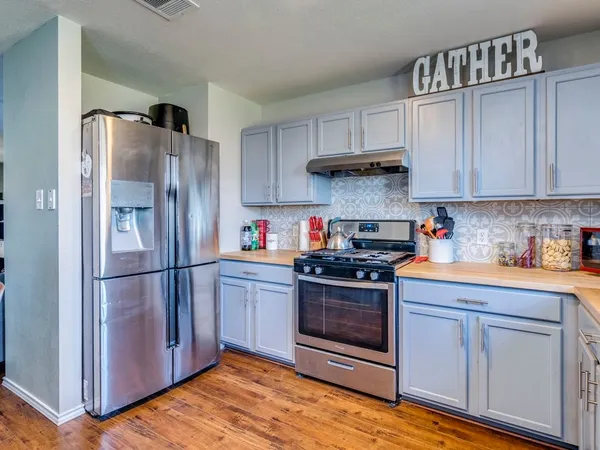 a kitchen with stainless steel appliances granite countertop a refrigerator sink and cabinets