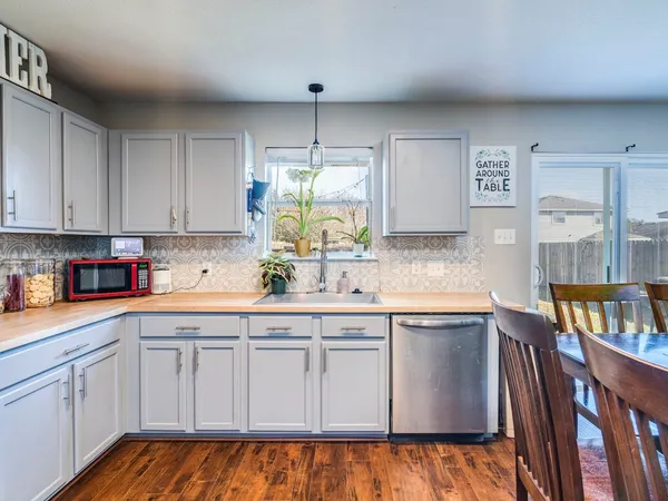 a kitchen with cabinets appliances a sink and a window