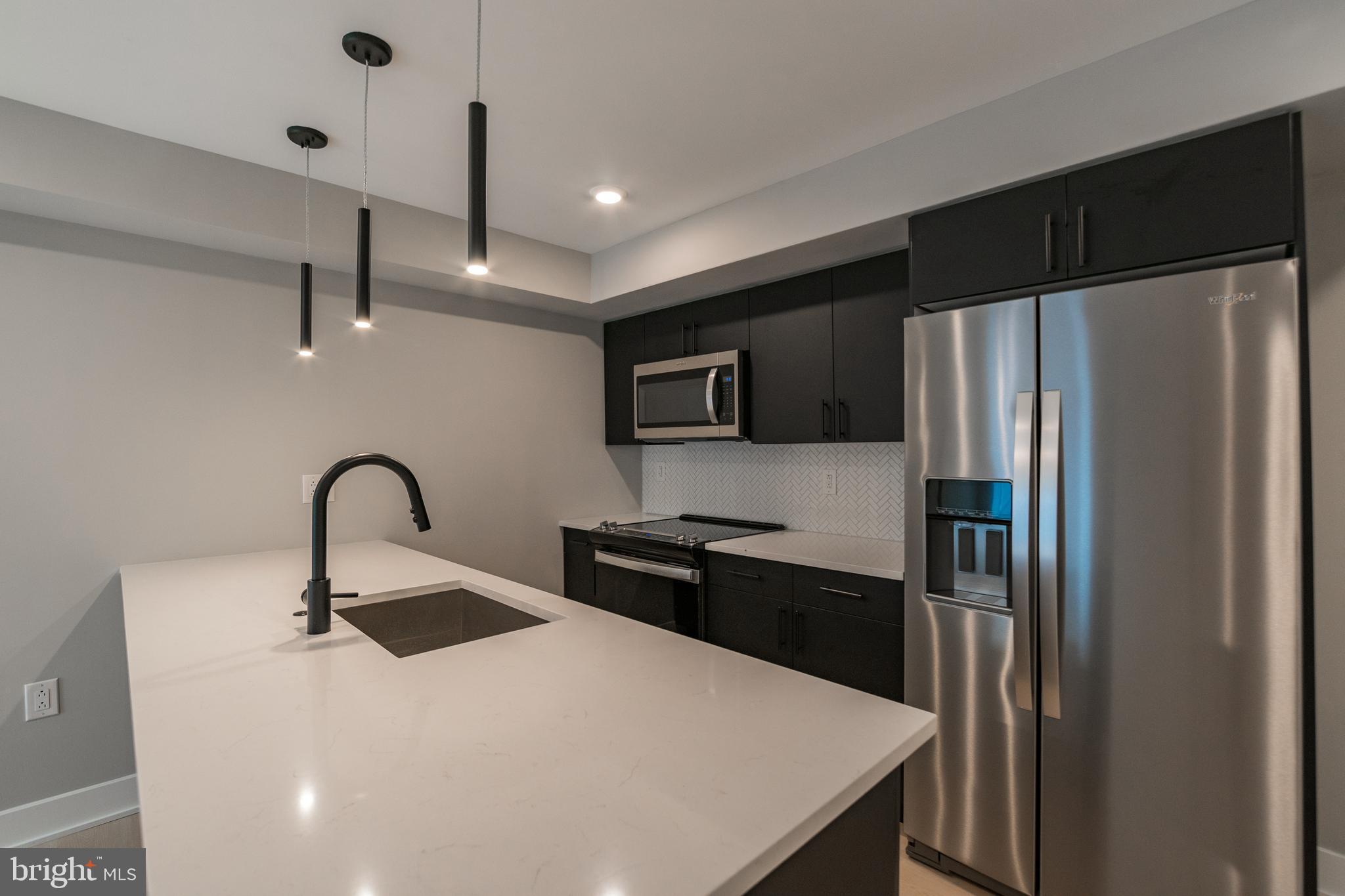 6604 Ridge Avenue, Unit 404 Philadelphia, PA 19128 - Photo 3 of 11 a kitchen with a refrigerator and a sink