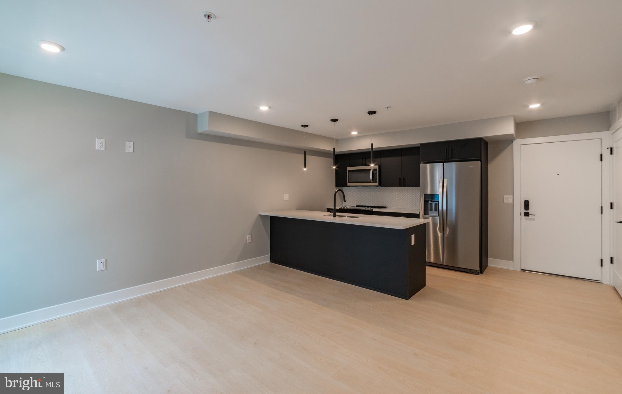 6604 Ridge Avenue, Unit 404 Philadelphia, PA 19128 - Photo 5 of 11 a kitchen with a refrigerator and a stove