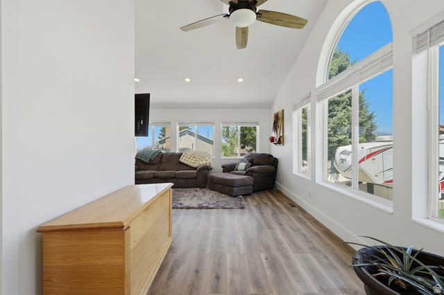 114 North Clark Lane Elk Ridge, UT 84651 - Photo 9 of 26 Living area featuring wood-finish flooring, vaulted ceilings with a ceiling fan, recessed lighting, and multiple windows including an arched accent window