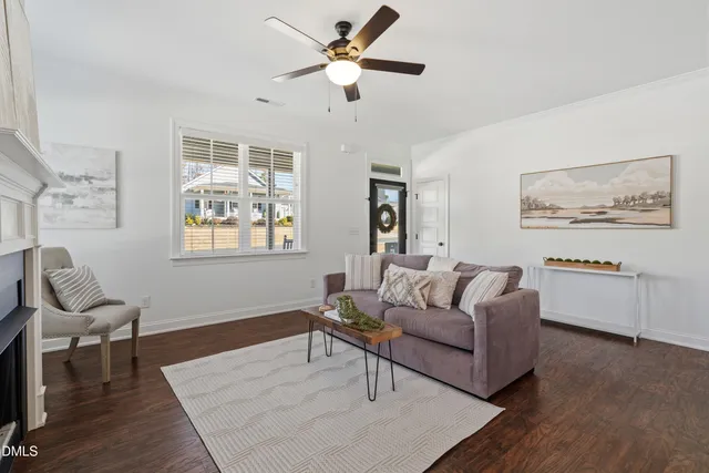a living room with furniture a desk and chair with wooden floor