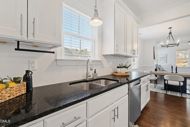 a kitchen with granite countertop a sink a stove and cabinets