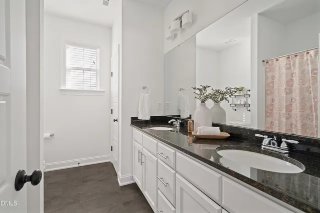 a bathroom with double sink and a mirror